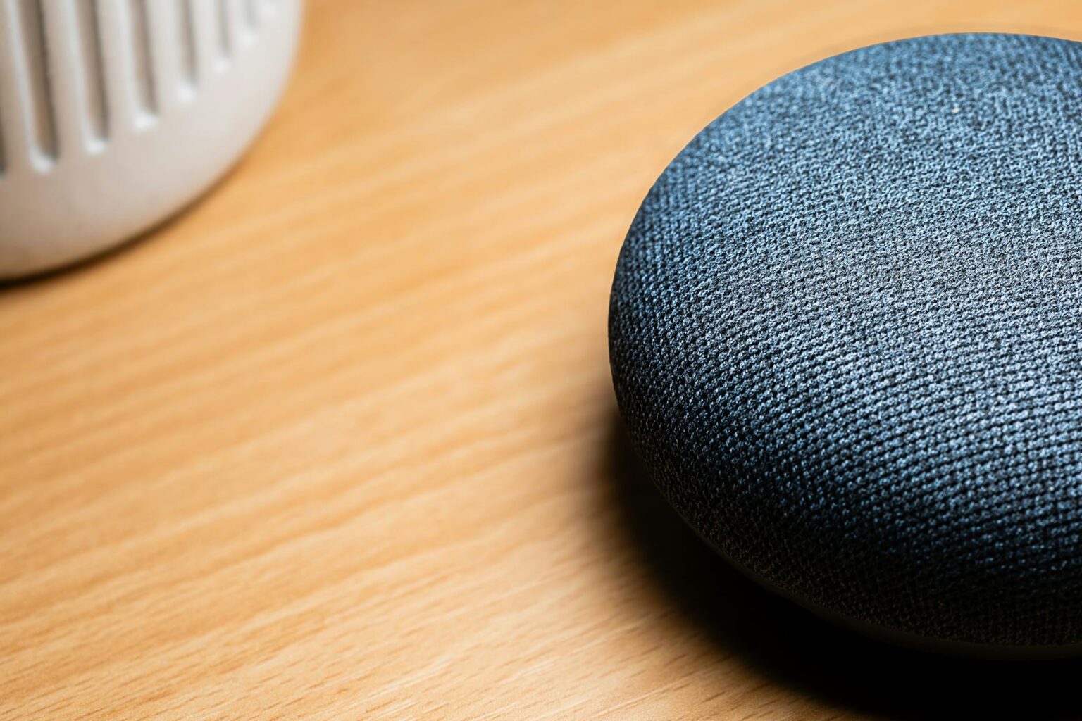Modern smart speaker device on a home counter, representing voice assistant technology in domestic spaces