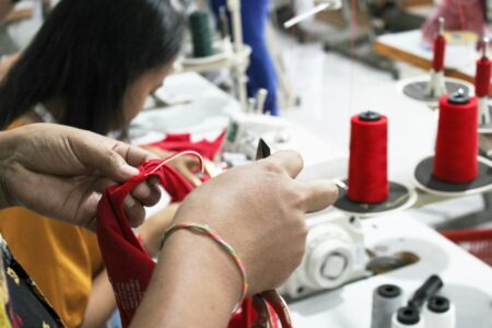 Underground Mending Circles Are Teaching Fast Fashion Repair Skills Group of people sitting in a circle working on textile repair projects with sewing supplies