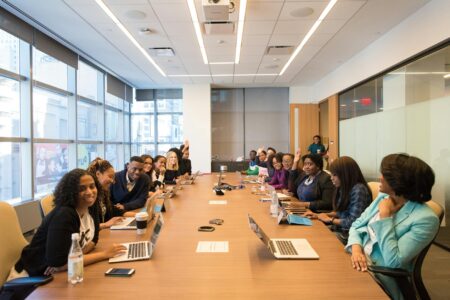 Corporate Book Clubs Are Just Team-Building Theater in Disguise Business professionals sitting around conference table in modern office setting