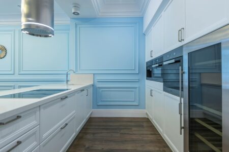 Modern communal kitchen with stainless steel appliances and large prep counters where residents can cook together