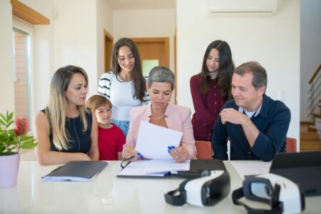 The Rise of Inheritance Coaching Among Wealthy Baby Boomer Parents Multi-generational family having a serious discussion around a conference table