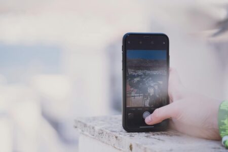 Close-up of smartphone screen displaying photo gallery with multiple thumbnail images
