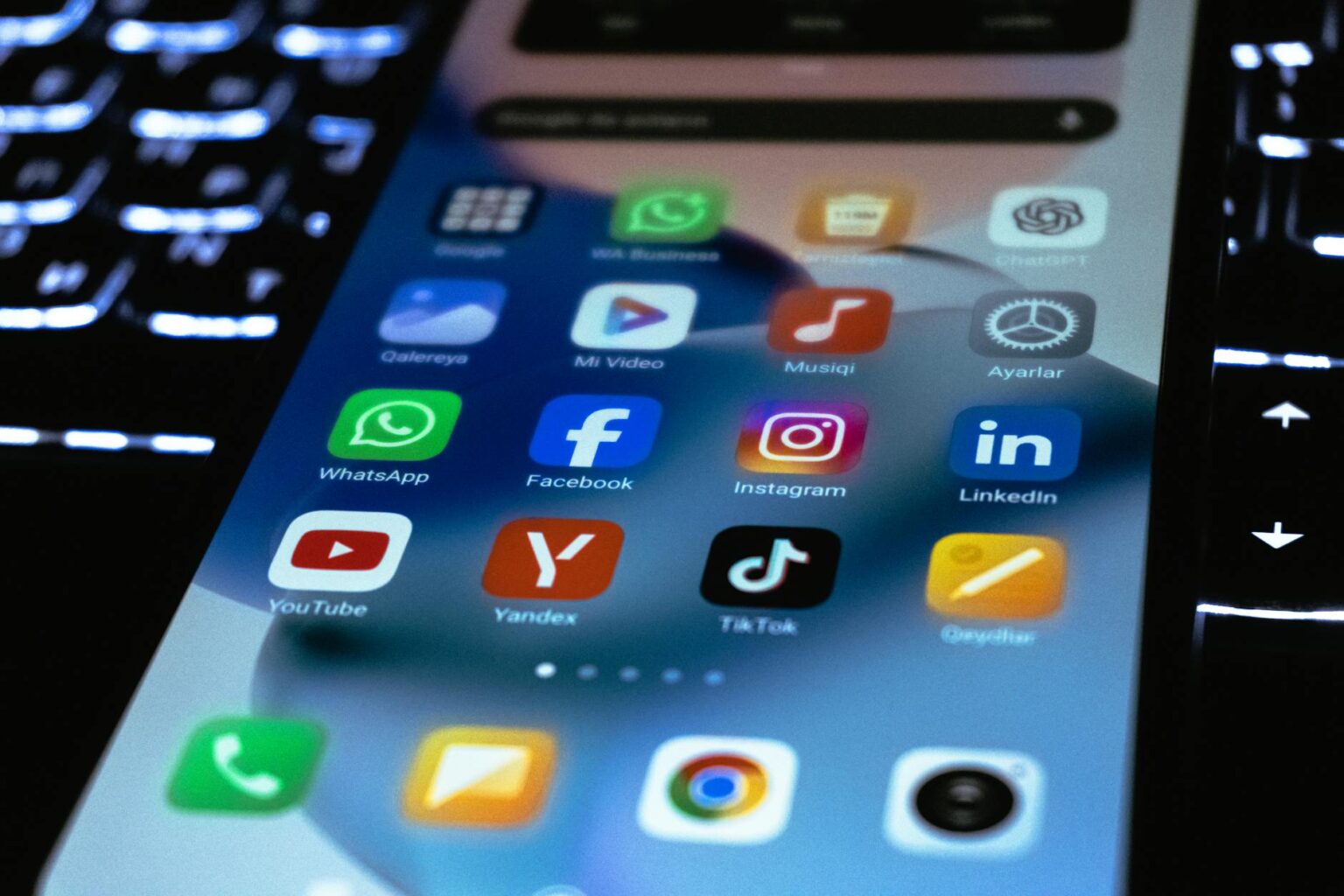 Person holding smartphone displaying various social media app notifications and feeds