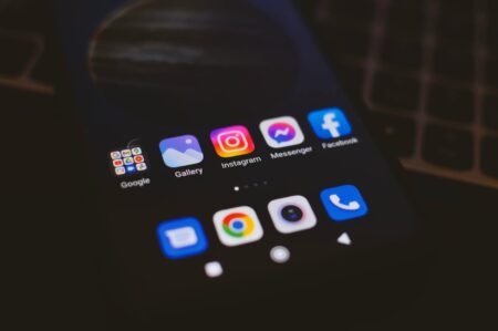 Why Celebrity Vulnerability on Social Media Has Become Just Another Marketing Strategy Person holding smartphone displaying social media feed with emotional posts and high engagement metrics