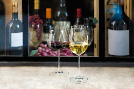 The Wine Industry’s Natural Wine Movement Is Just Expensive Gatekeeping Wine glasses filled with cloudy natural wine on wooden table in trendy wine bar setting