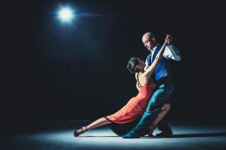 Professional ballroom dancers performing in elegant costumes on stage