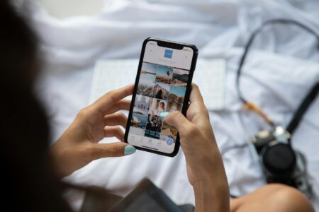 Person holding smartphone showing social media interface with notifications