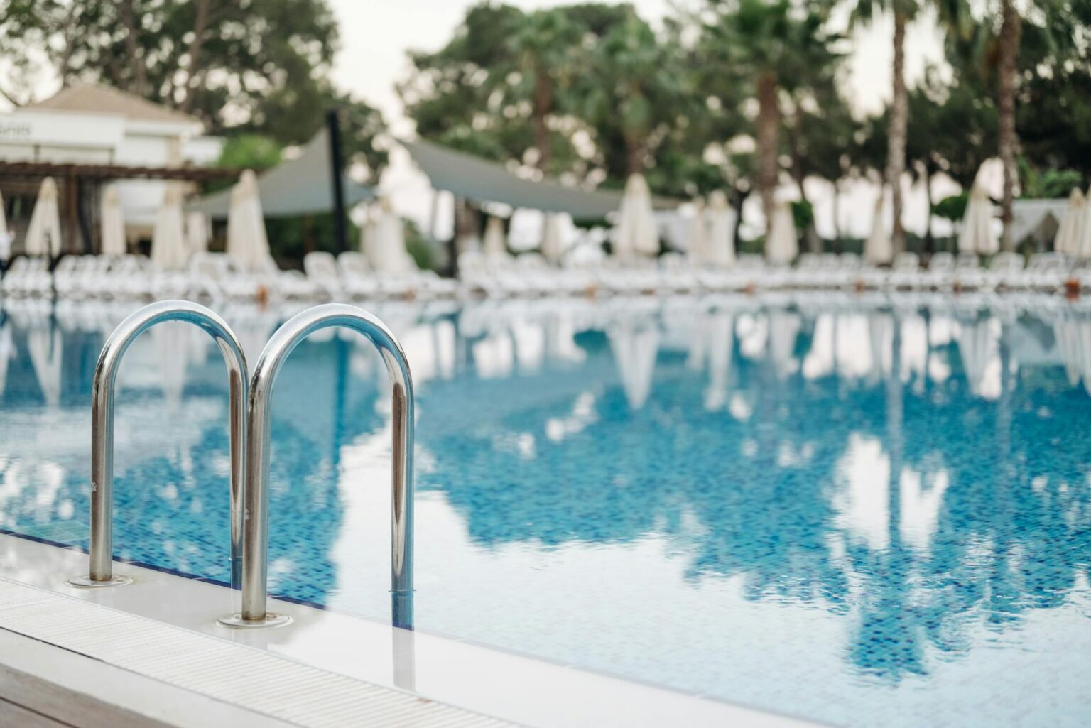 Tropical resort pool area with palm trees and luxury amenities