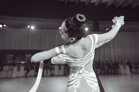 Professional ballroom dancers performing elegant routine on polished dance floor