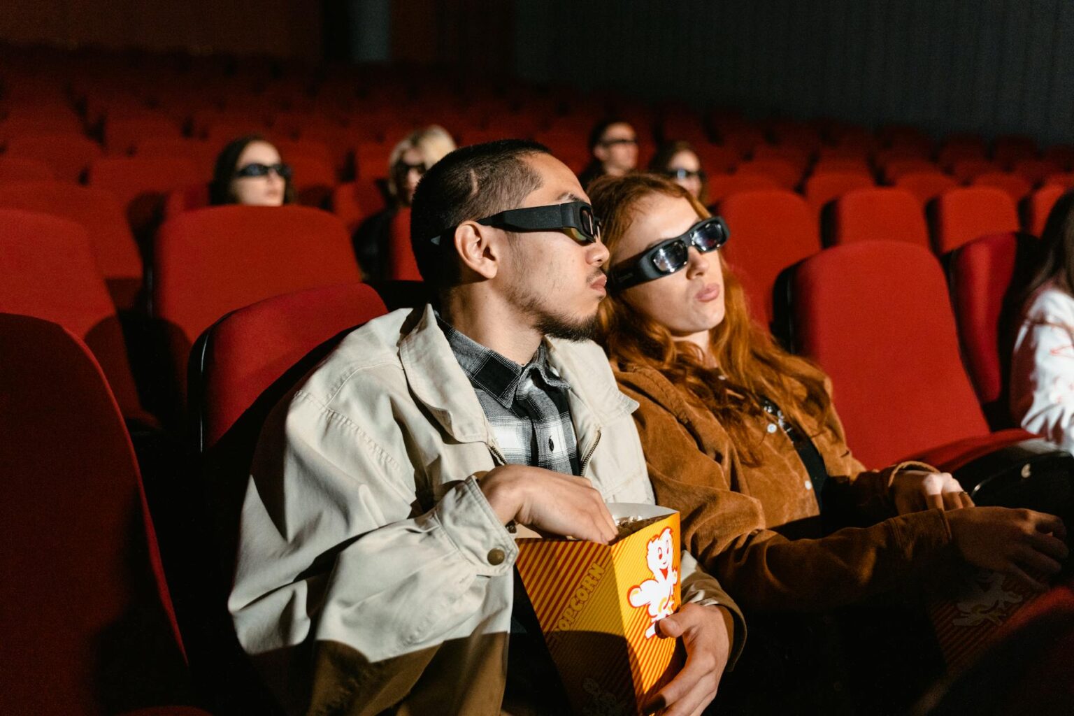 Empty movie theater seats with screen in background