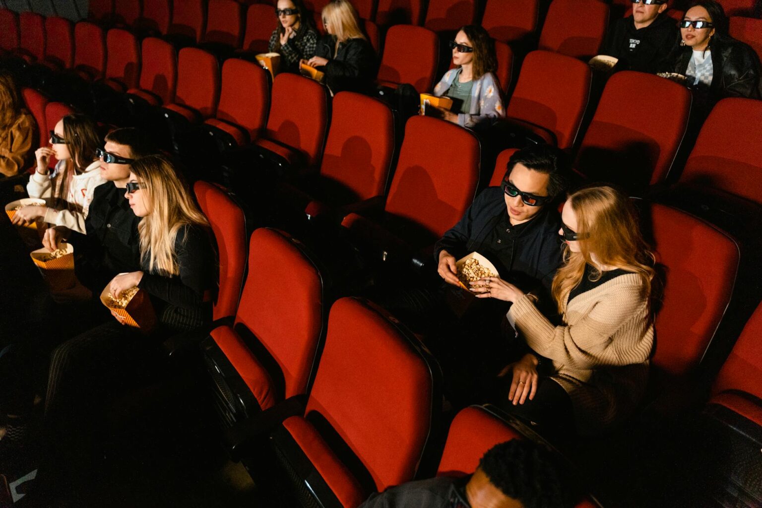 People watching a movie in a darkened theater with projected light