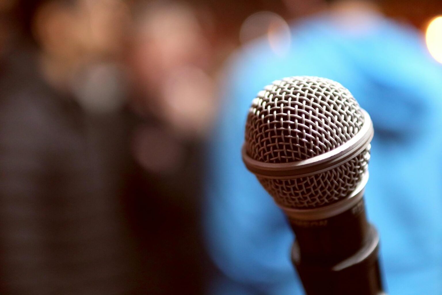 Late Night TV Hosts Are Embracing Stand-Up Comedy Comebacks Stand-up comedy stage with microphone under spotlight in dark venue