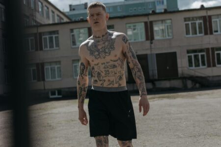 Track Shorts Overtake Denim as Summer’s Go-To Bottom Woman wearing black track shorts with casual summer top