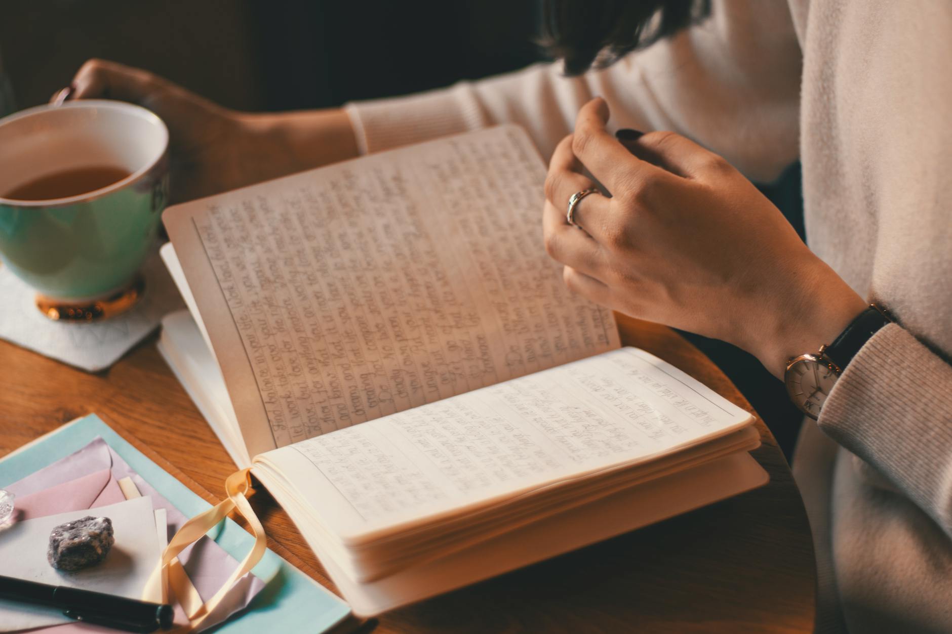 A woman writing in a journal by a window in soft morning light