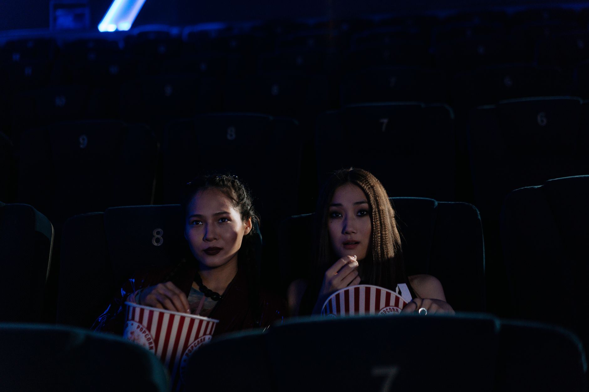 Two people watching a film together on a couch in a dimly lit room