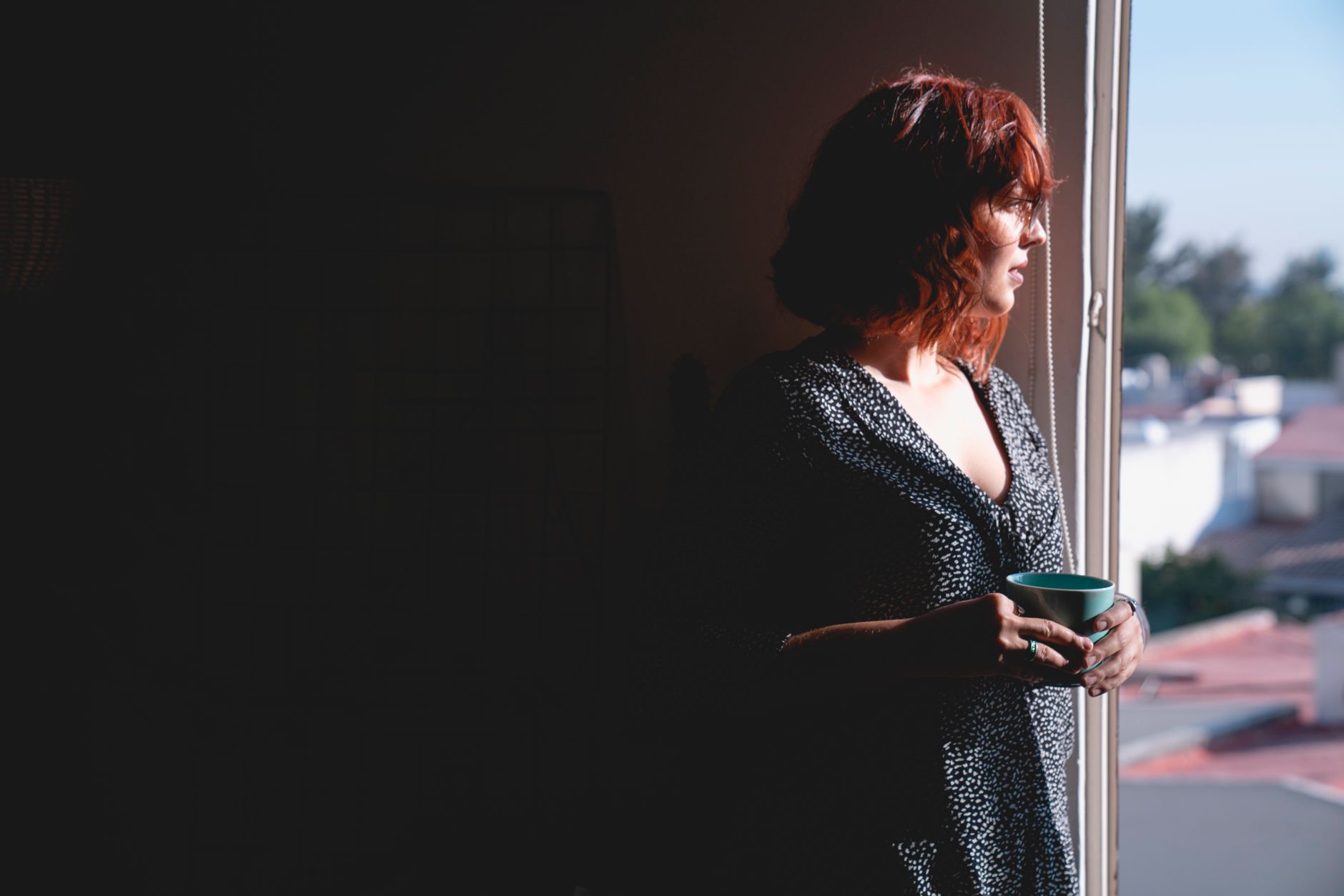 Woman sitting alone looking away, expression unreadable