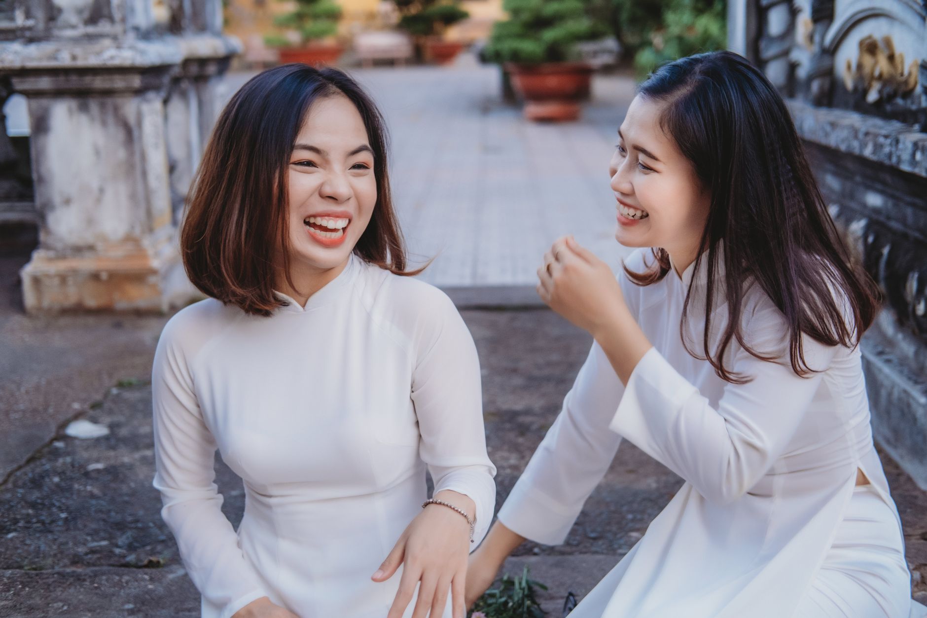 Two young women laughing and sitting close together, suggesting a close friendship or sisterly bond