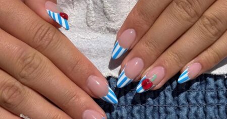 Close-up of a detailed nail manicure with red and white polka dot French tips