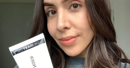 A white tube of cleansing balm on a clean bathroom surface