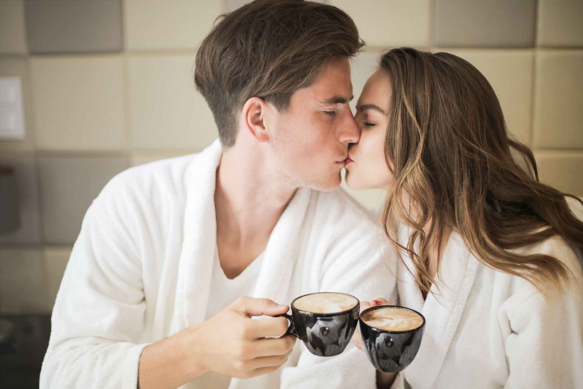 Person handing a cup of coffee to a partner in a calm domestic setting