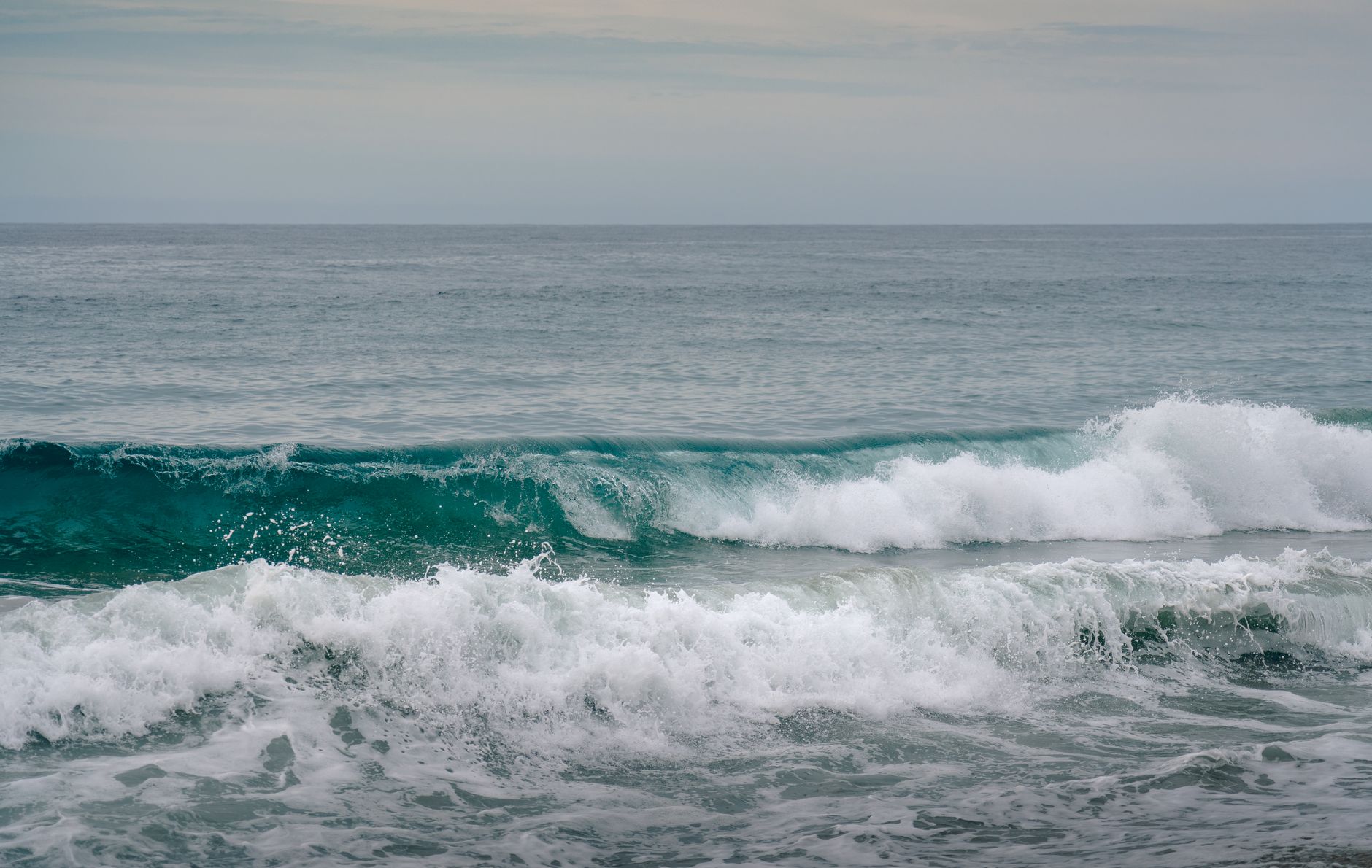 Vast open ocean with no visible shoreline under a grey sky
