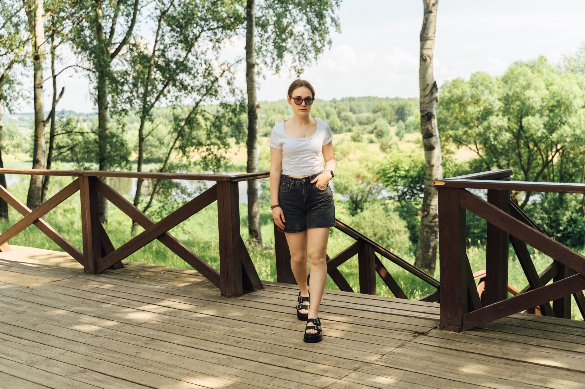 Person wearing relaxed-fit cargo pants in a sunny outdoor setting during summer travel