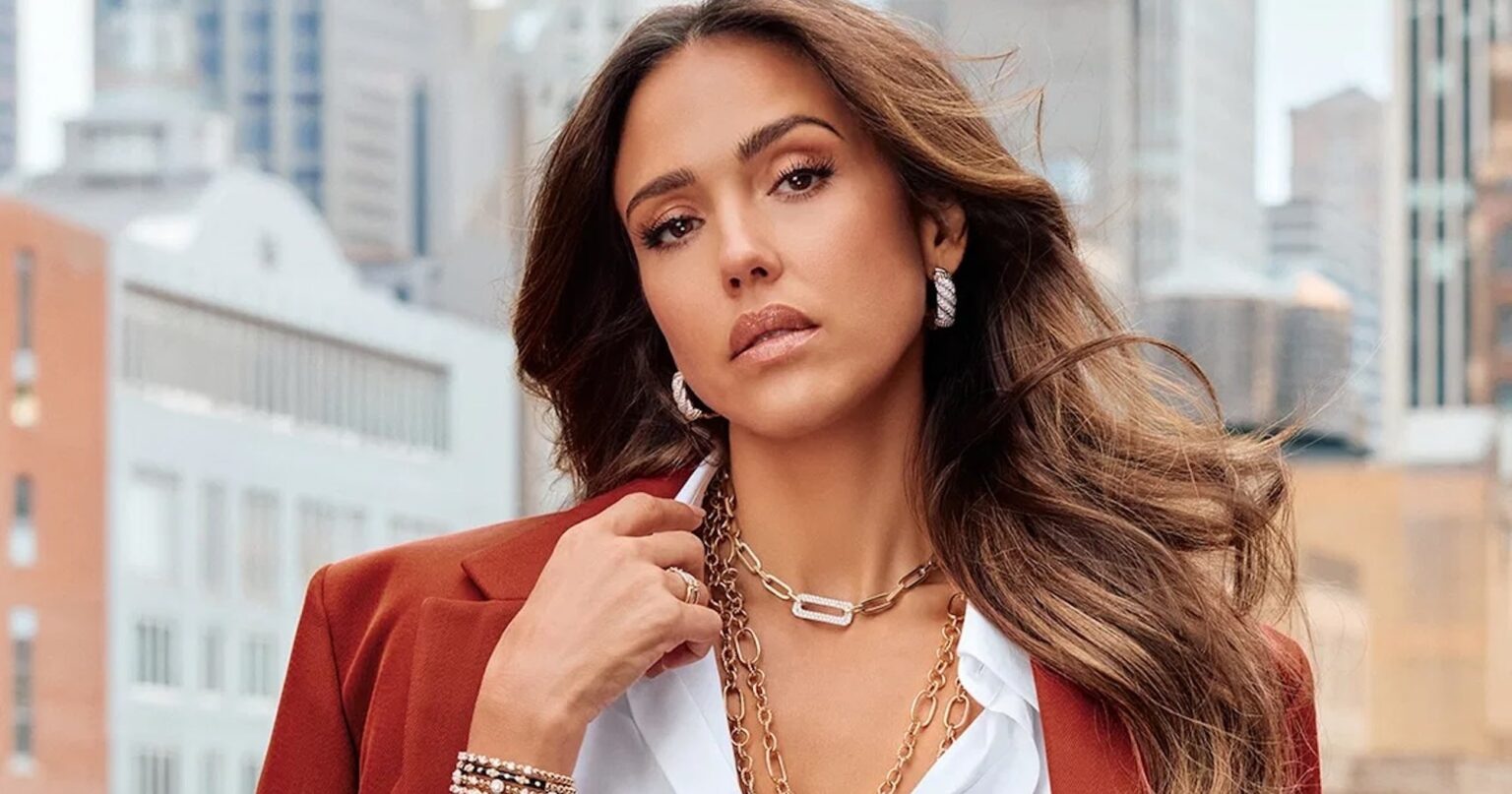 Close-up of layered gold and diamond bracelets on a wrist against neutral background