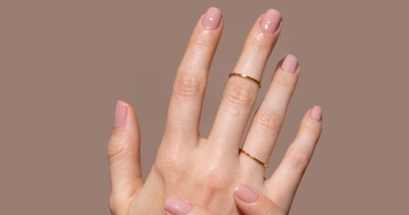 Close-up of hands with gel nail extensions showing redness around the nail fold