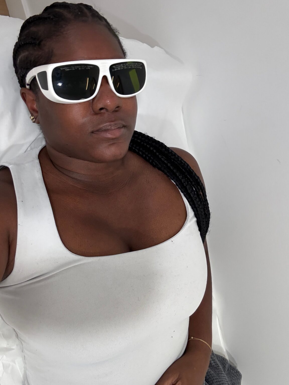 A Laser Burn Left a Scar. Then Milan Laser Changed Everything. A woman examining her skin in a bathroom mirror during a daily skincare routine