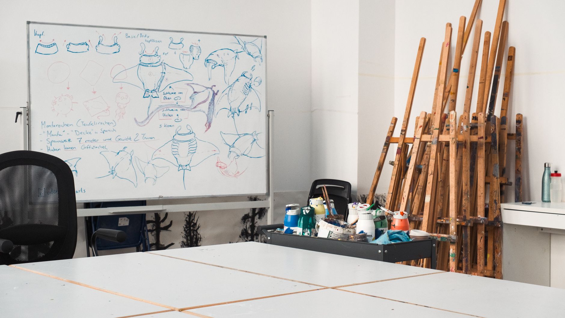 Artist sketching animated characters at a professional studio desk