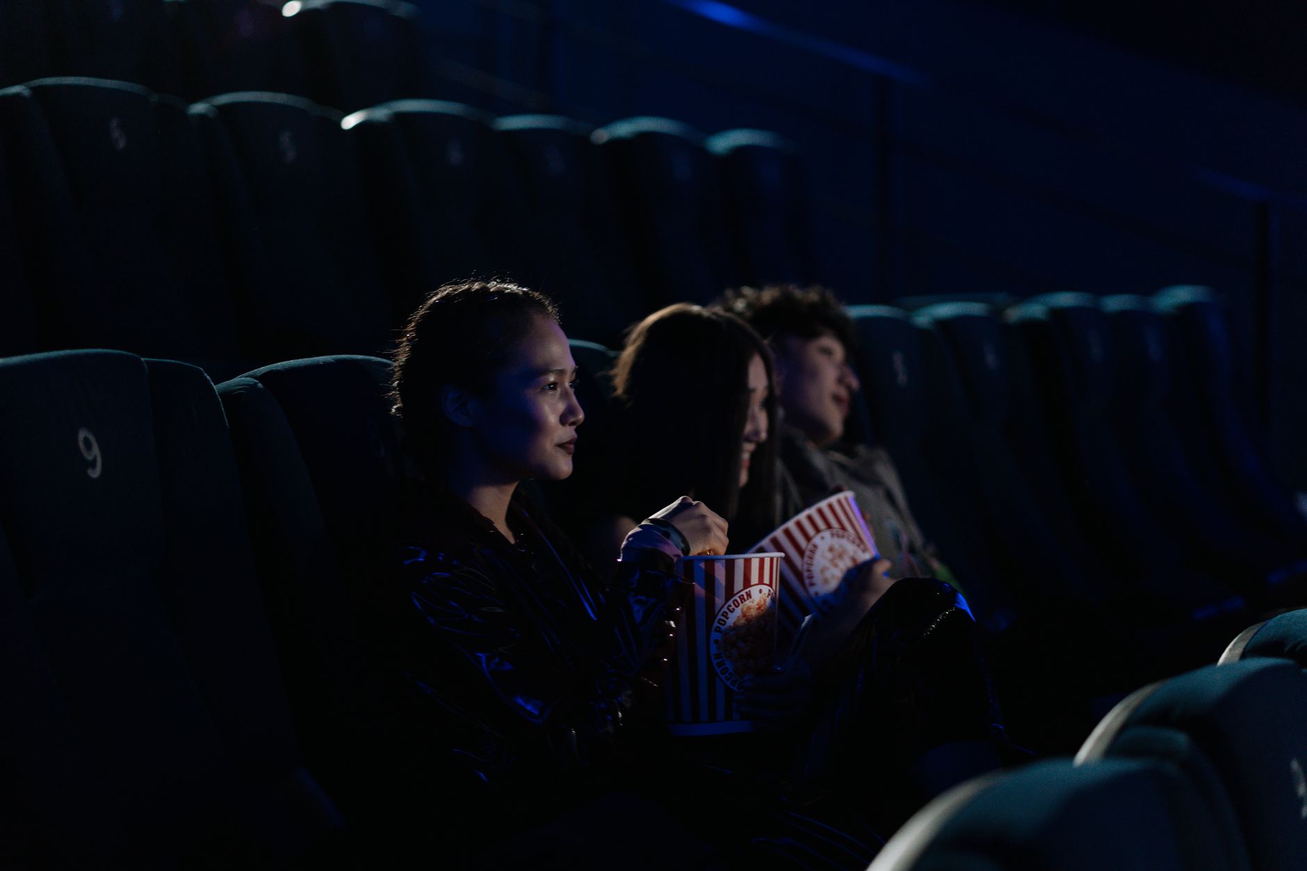 Audience seated in a darkened cinema watching a romantic film