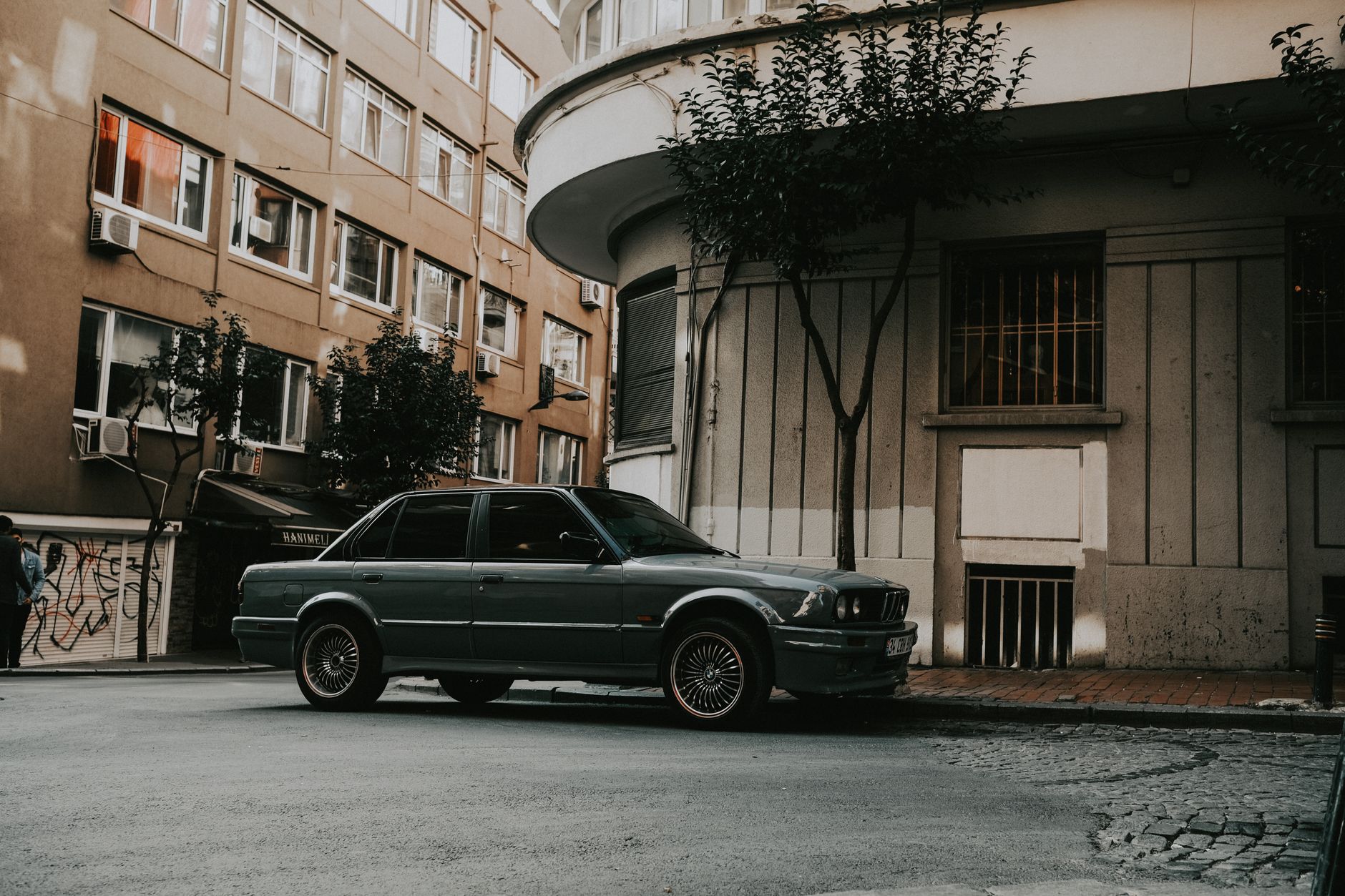 A car driving past on a city street at dusk