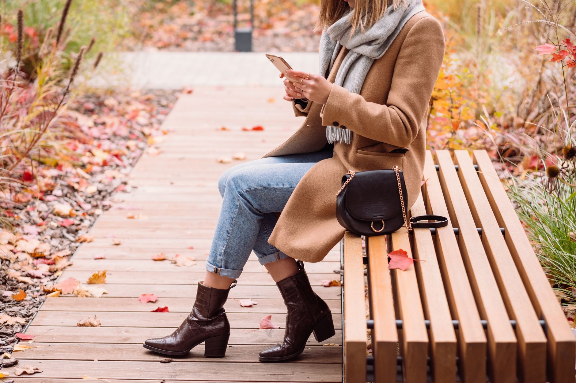 A fall outfit featuring a babydoll dress styled with boots and layered accessories