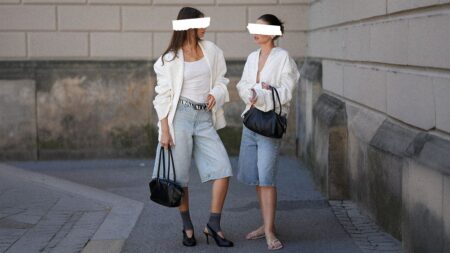 Two women browsing clothing racks together in a boutique